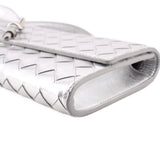 Silver metallic clutch corner close-up with woven pattern and folded edge
