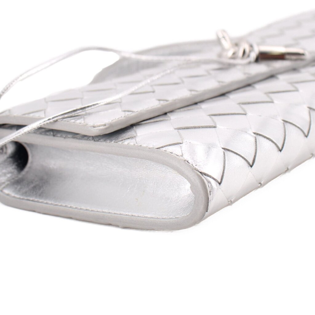 Silver metallic clutch end close-up with woven trim and opening