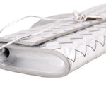 Silver metallic clutch end close-up with woven trim and opening