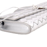 Silver metallic clutch end close-up with woven trim and opening