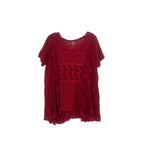 Red embroidered peasant top with scalloped neckline, short sleeves, and patterned panels