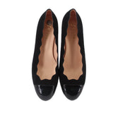 Pair of black wedge flats with pointed glossy toe and tan interior