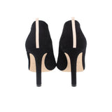 Black suede heeled booties, back view with stiletto heel and light elastic pull tab