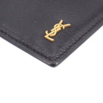 Black leather card case corner with gold YSL logo and neat stitching