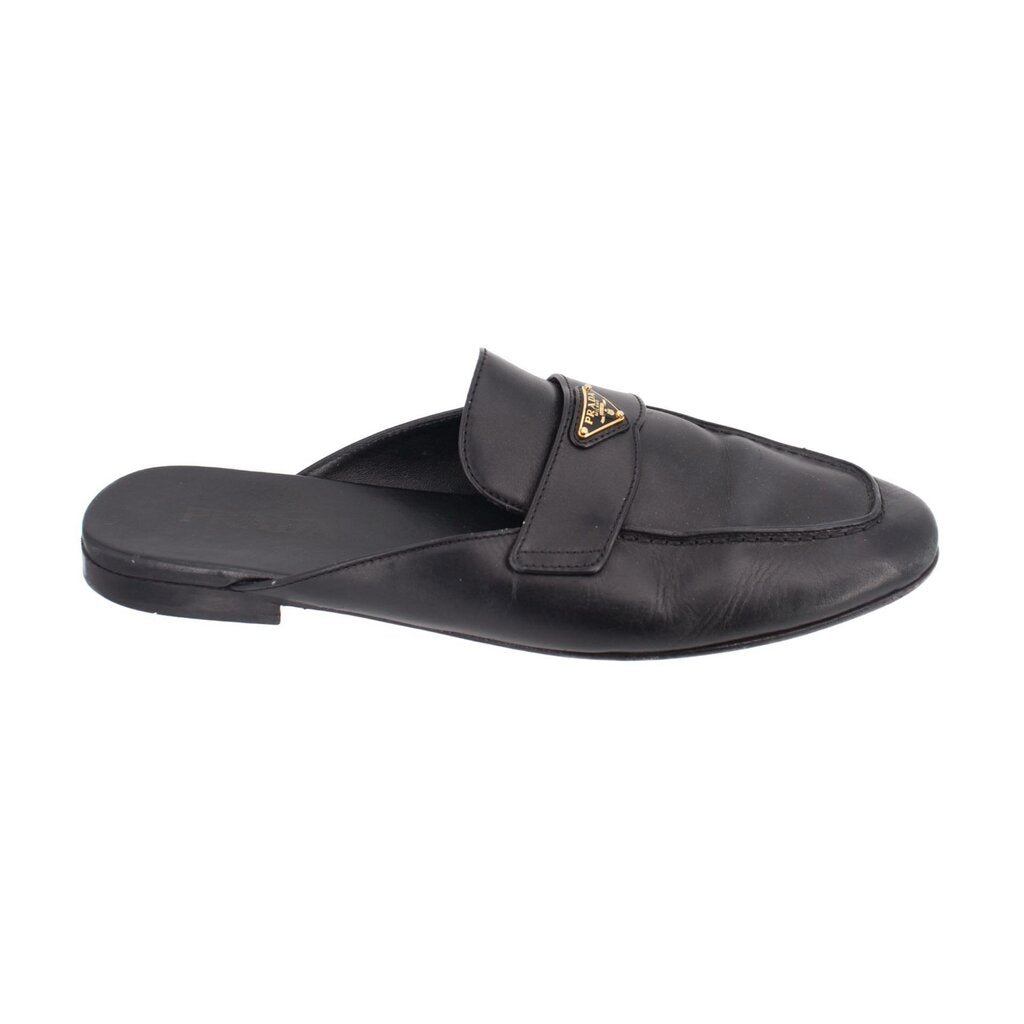 Black leather slide loafer, side view, with PRADA gold logo buckle strap
