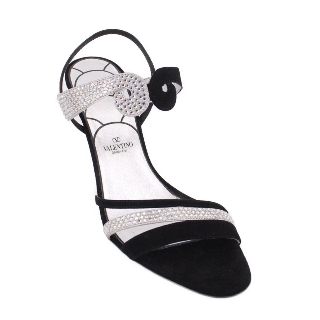 Black heeled sandals with rhinestone bow detail and ankle strap
