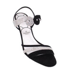 Black heeled sandals with rhinestone bow detail and ankle strap