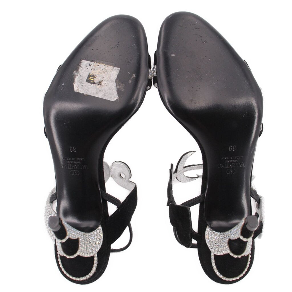 Black heeled sandals with rhinestone ankle straps and embossed heel interiors