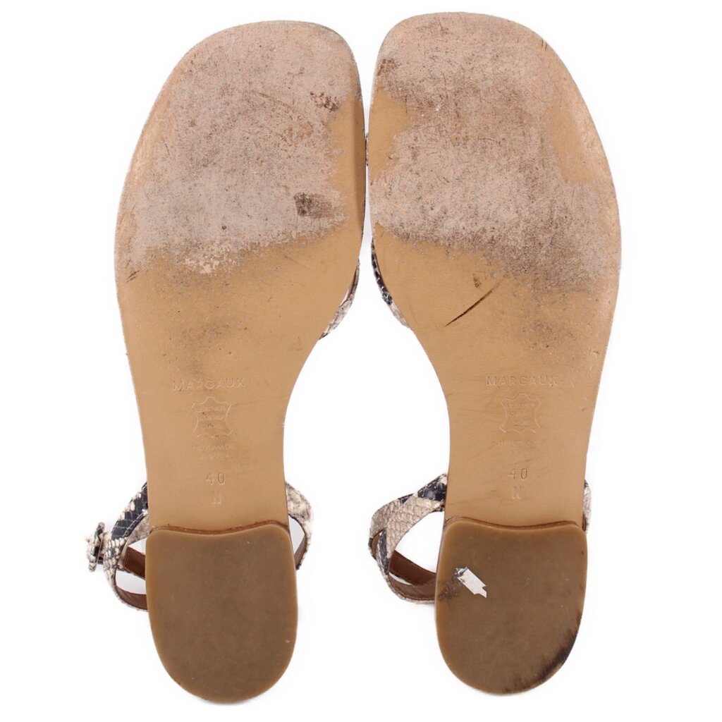 Beige sandal soles with textured undersides and strap cutouts at the foot