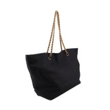 Black tote bag with gold-tone chain handles and wide slouchy silhouette