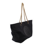 Black tote bag with gold-tone chain handles and large embossed front logo