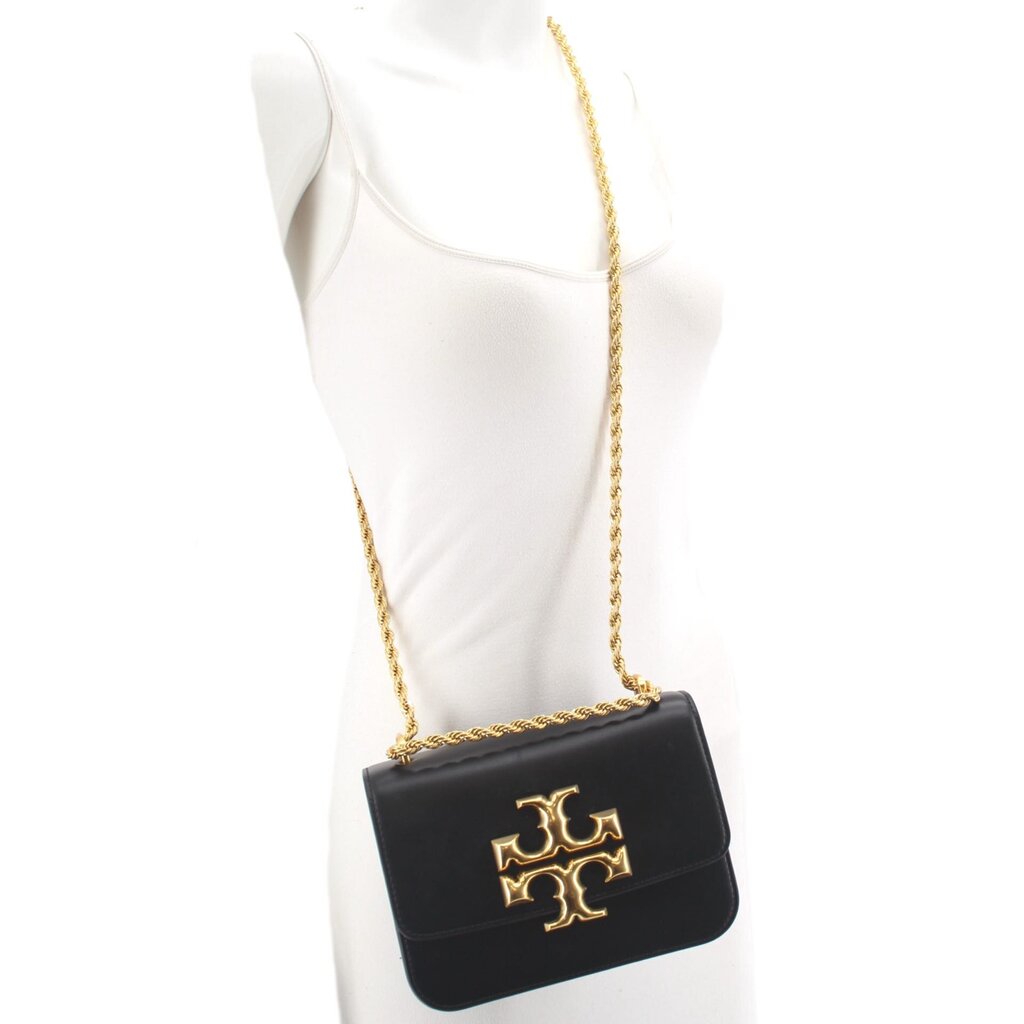 Small black crossbody bag with gold logo flap and braided chain strap on model