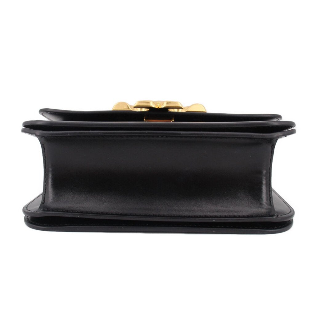 Black leather crossbody bag underside view with snap clasp and flat base