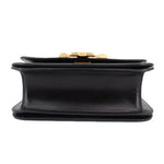 Black leather crossbody bag underside view with snap clasp and flat base