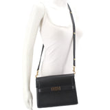 Black leather crossbody shoulder bag with front flap, gold logo tab, and chain strap