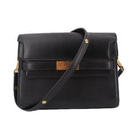 Black leather shoulder bag with flap, gold hardware, and adjustable crossbody strap