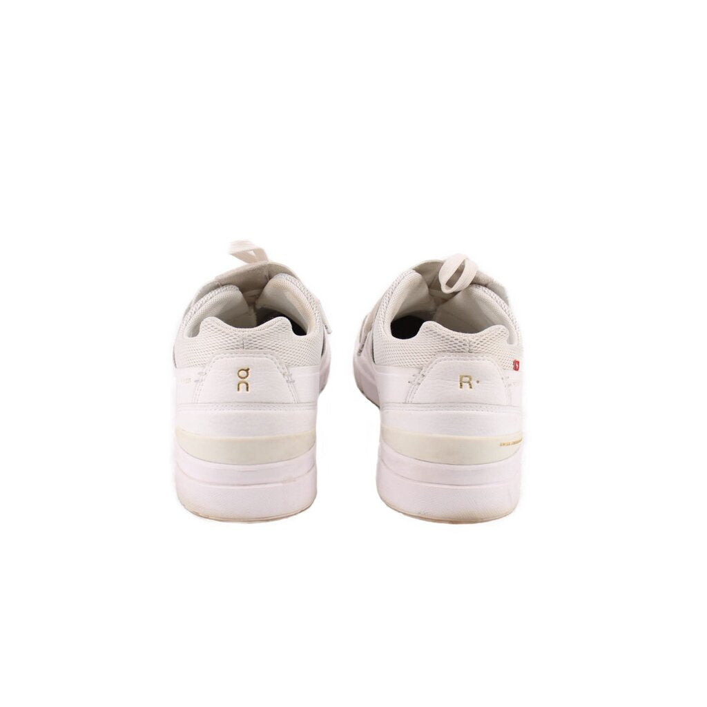 White sneakers heel view with cushioned collar and logo on back tab
