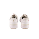 White sneakers heel view with cushioned collar and logo on back tab