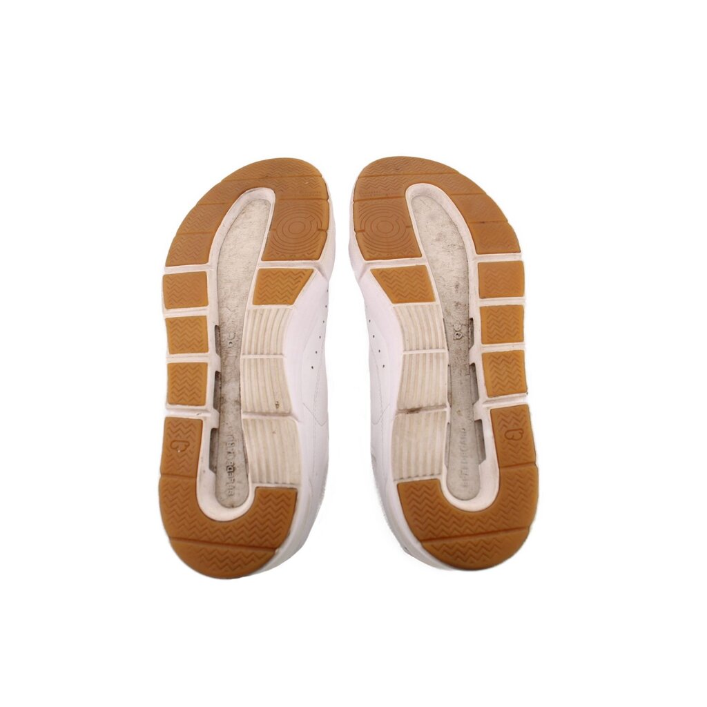 White sneaker outsoles with textured rubber tread in tan and light gray
