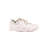 White low-top sneakers with mesh side panels, lace-up closure, and padded collar