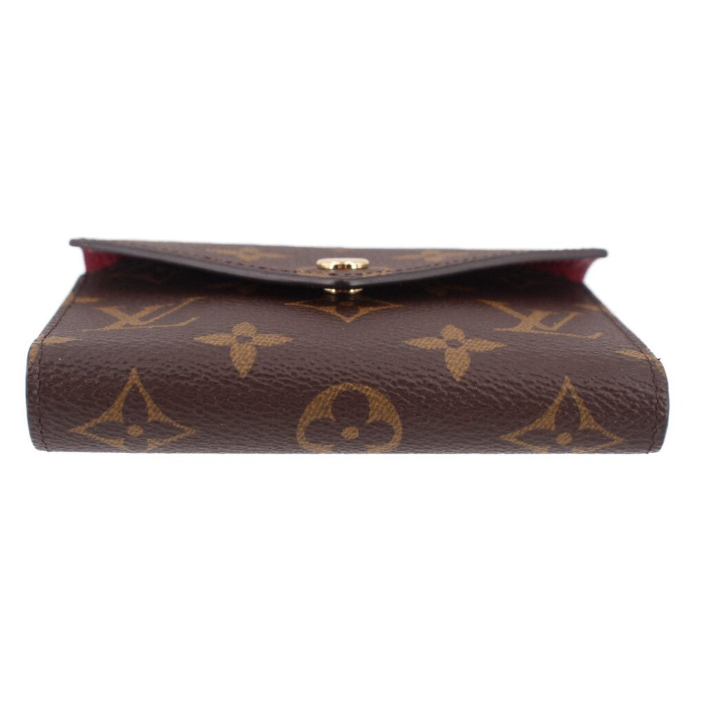 Louis Vuitton Victorine monogram wallet top view with gold clasp and red-lined underside