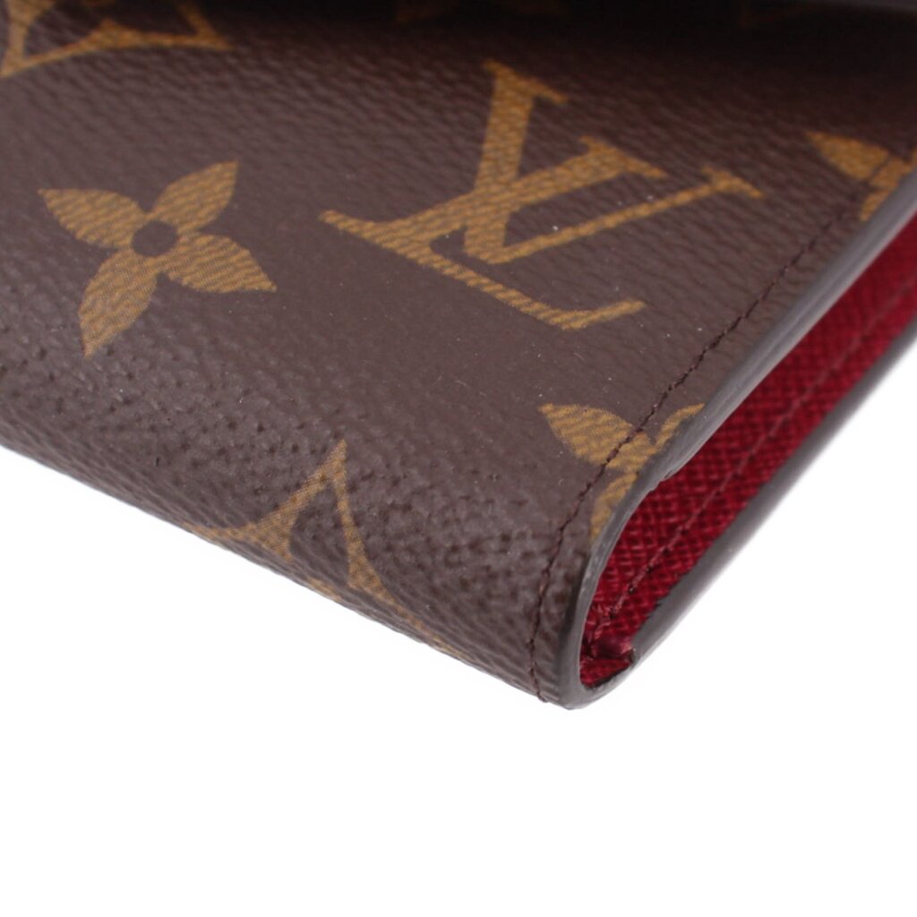 Louis Vuitton Victorine monogram wallet corner close-up with brown exterior and red lining