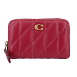 Fuchsia quilted zip wallet with gold C logo and zipper hardware.
