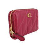 Fuchsia quilted zip wallet with side pull tab and gold zipper hardware.