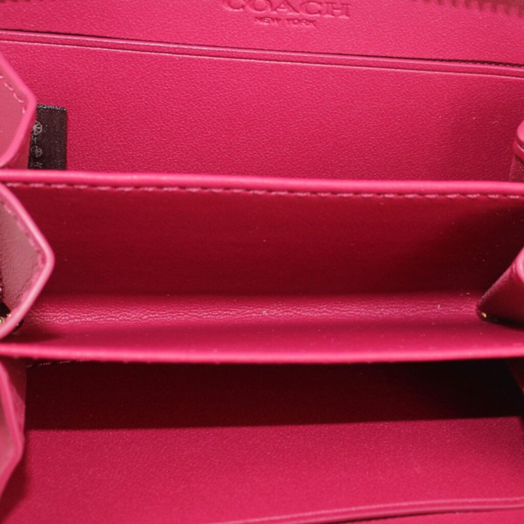 Fuchsia wallet interior with COACH logo and zip pocket lining.