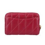 Fuchsia quilted zip wallet with gold C emblem and stitched paneling.