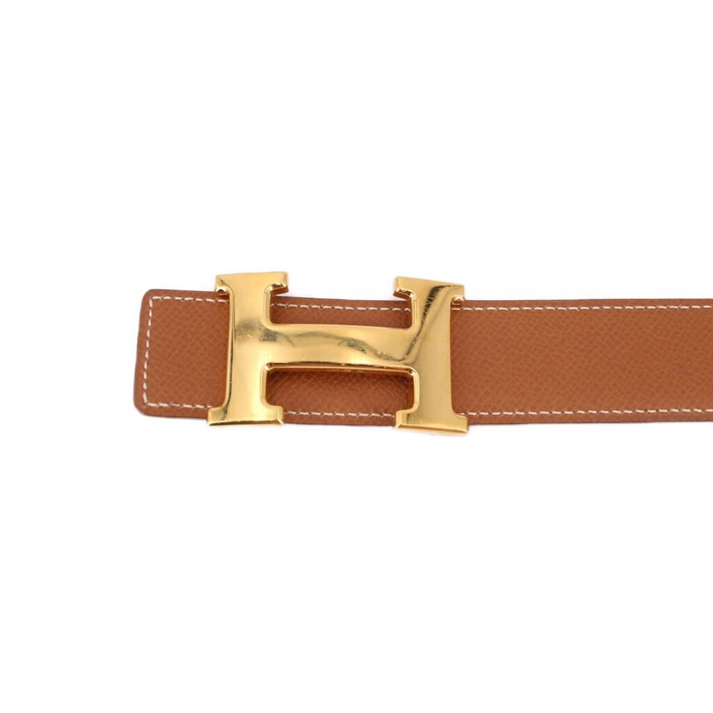 Reversible leather belt, tan side with gold-tone H buckle close-up