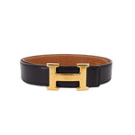 Reversible leather belt, black and tan, gold-tone H buckle close-up
