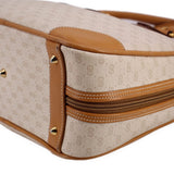 Beige monogram canvas bag corner with tan leather piping, rivets, and double-zip detail