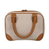 Beige vintage duffel-style top handle bag with tan leather trim and dual top handles