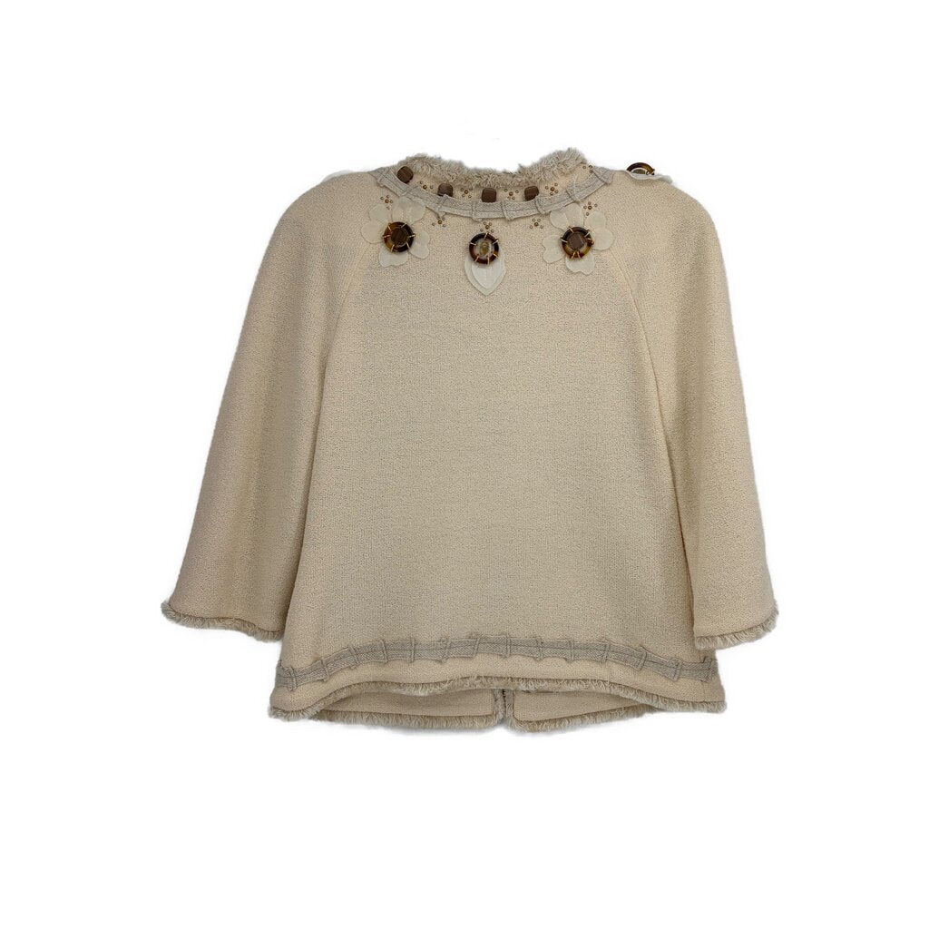 Cream embellished jacket with three decorative badges at yoke and scalloped hem