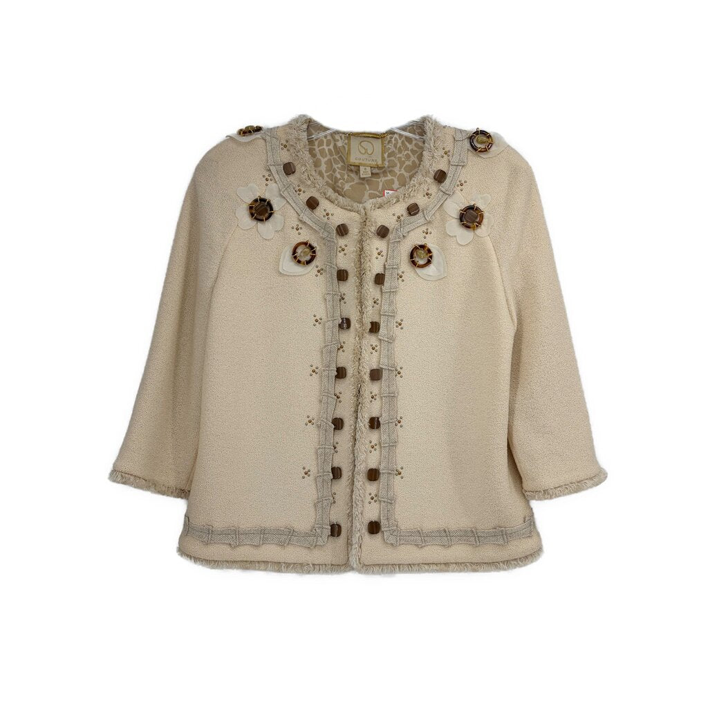 Cream embellished jacket with faux button trim, round neckline, and decorative medallions