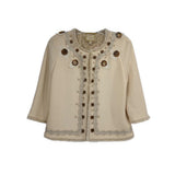 Cream embellished jacket with faux button trim, round neckline, and decorative medallions
