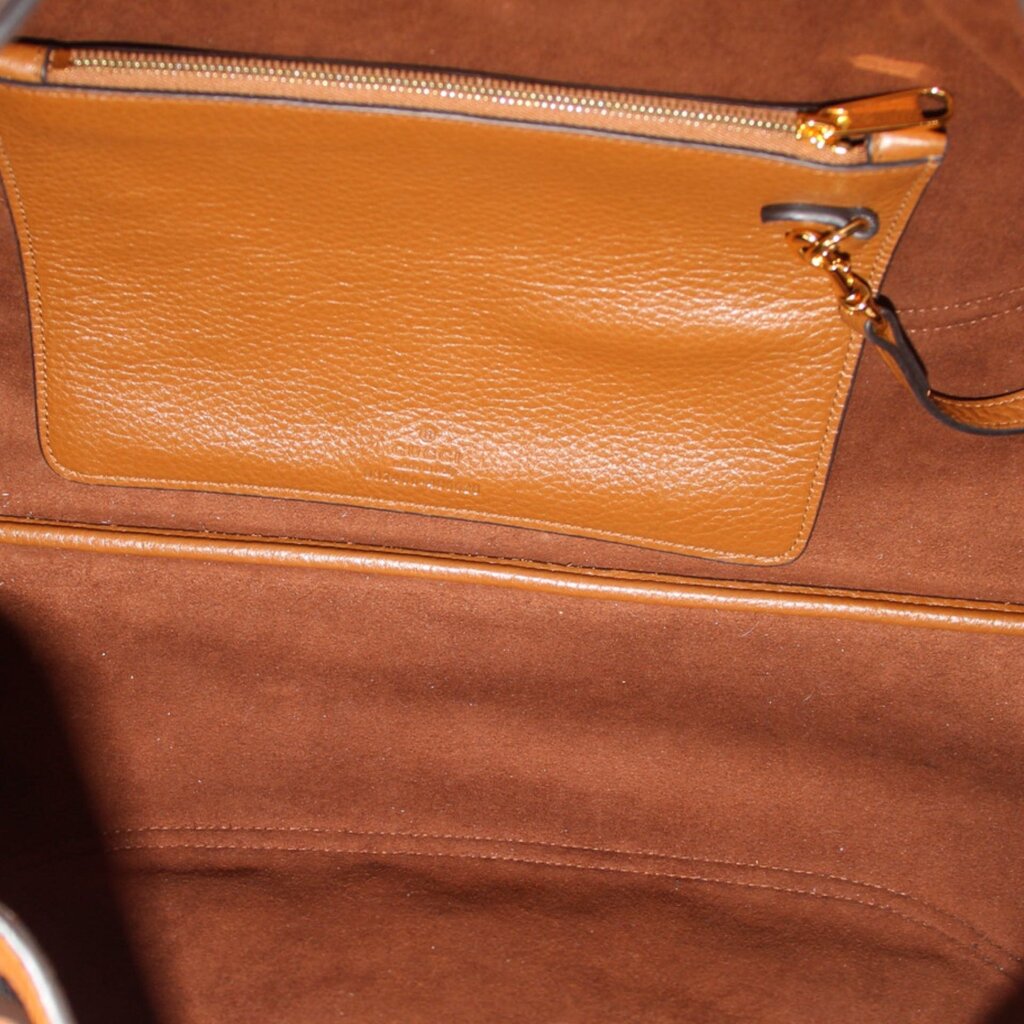 Brown leather bag interior with zip pocket and gold zipper pull