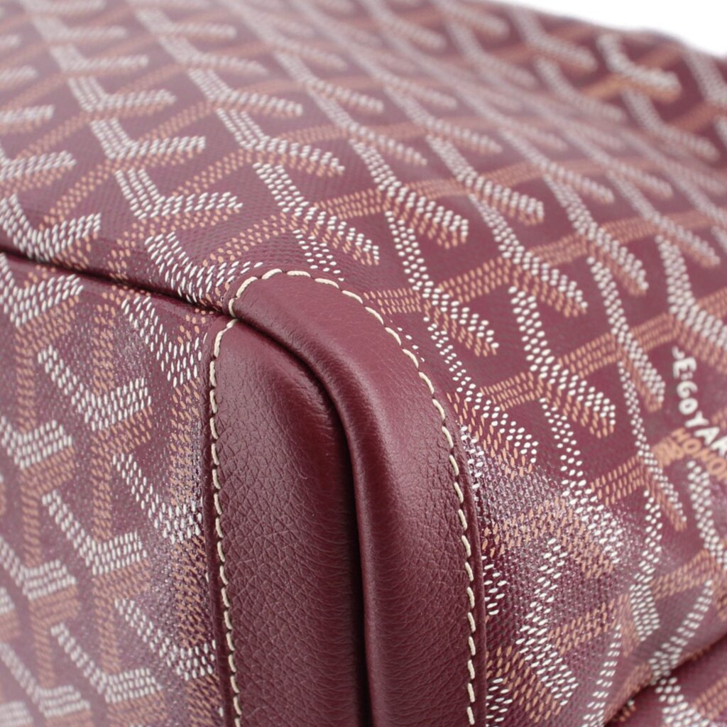 Maroon patterned canvas corner with leather trim and visible edge stitching