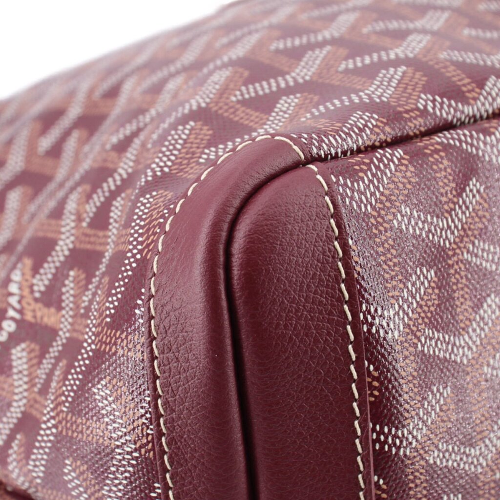 Maroon leather handle base with stitched seam on patterned canvas