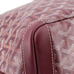 Maroon leather handle base with stitched seam on patterned canvas