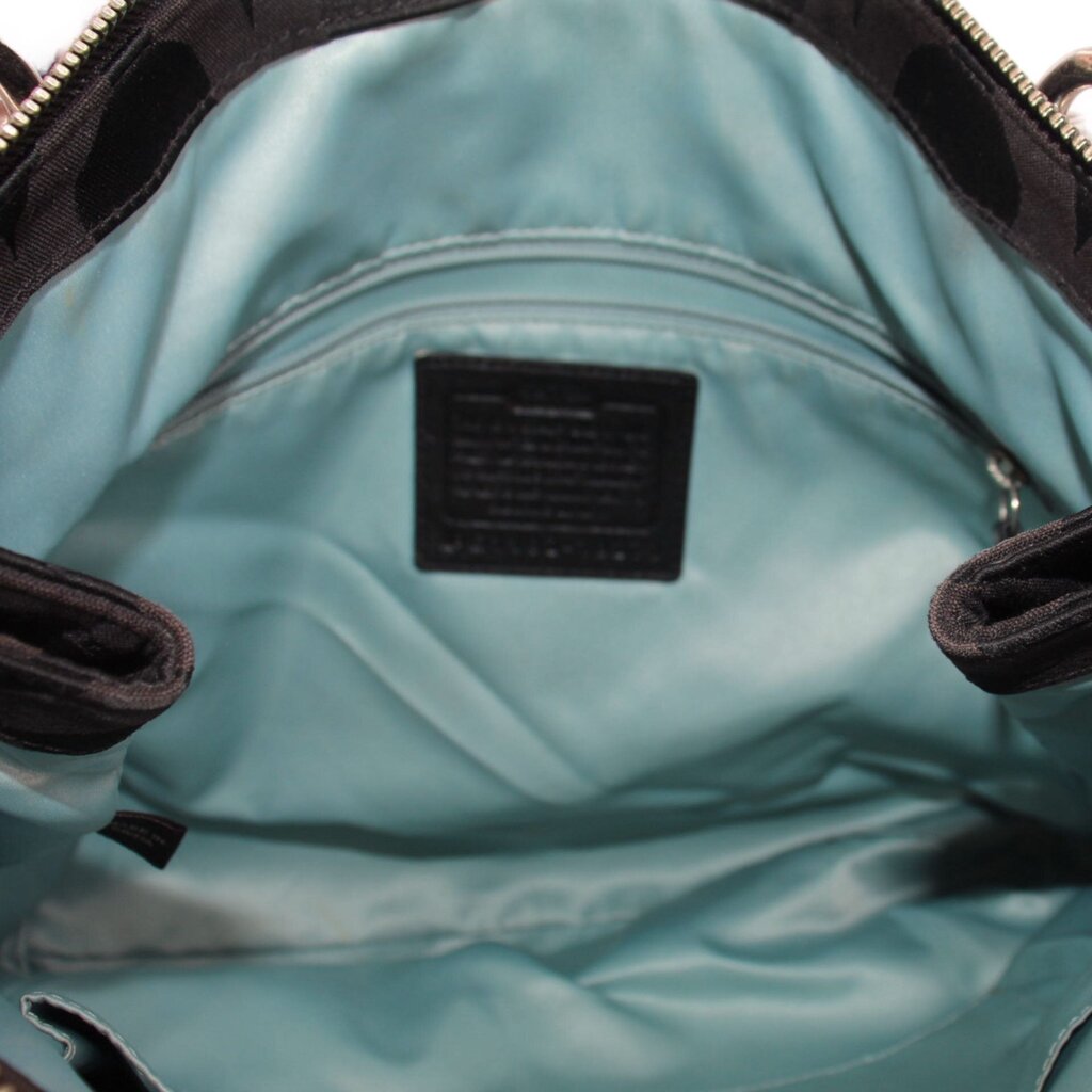 Teal lining inside shoulder bag with fabric brand tag and side slip pockets