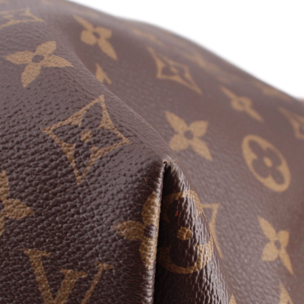 Brown Monogram leather edge close-up with stitched border and embossed marks