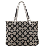 Black and beige op-art tote-style shoulder bag with top zip and metal buckles