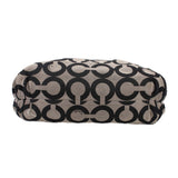 Black and beige op-art duffel-style shoulder bag with rounded top and small logo patch