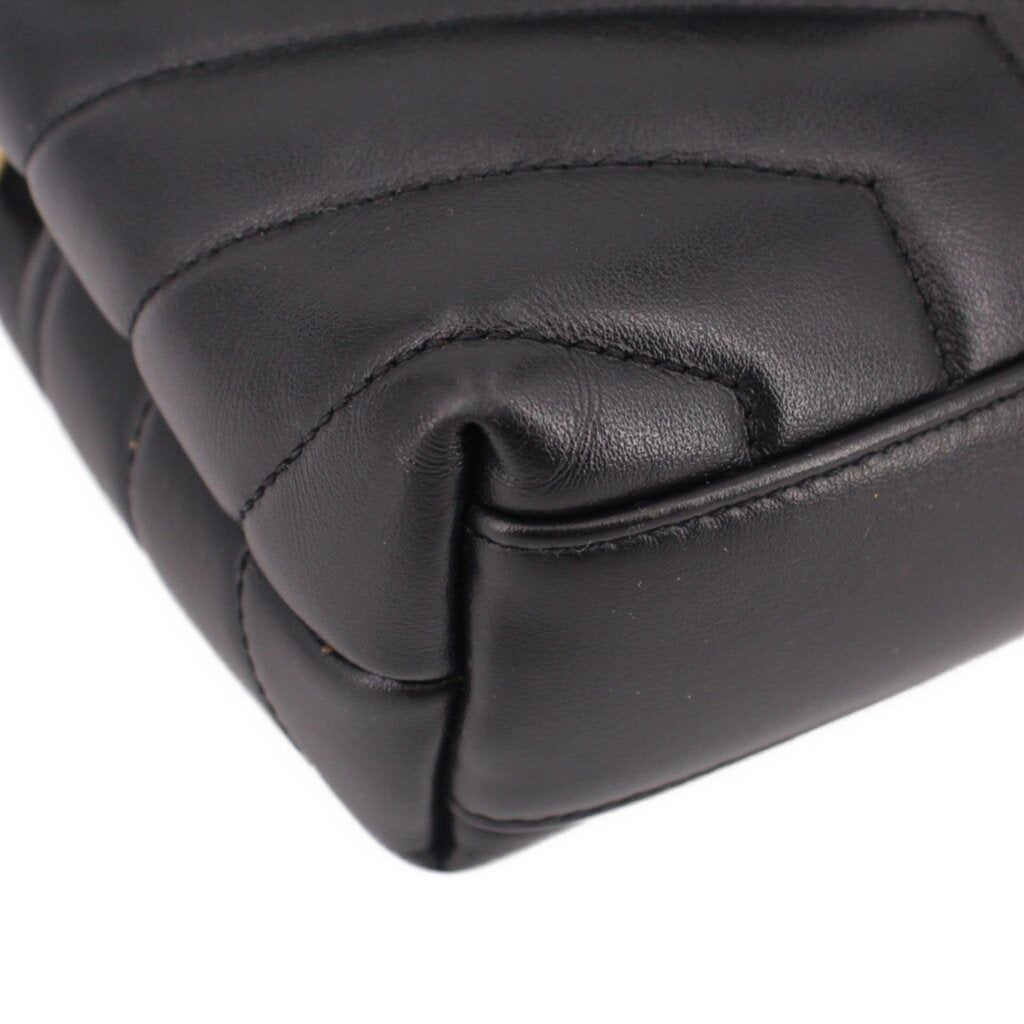 Black leather crossbody bag corner close-up with rounded quilting seam