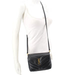 Black quilted leather crossbody bag worn on adjustable strap with YSL logo