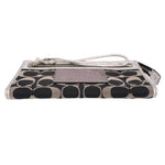 COACH signature wristlet pouch side view with wrist strap and mauve leather tab
