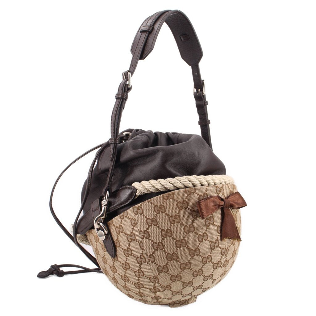 Brown logo canvas bucket shoulder bag with black pouch, braided band, brown leather bow