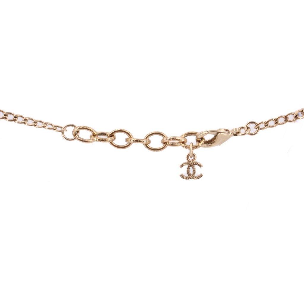 Gold-tone necklace clasp with CHANEL logo charm and linked chain.